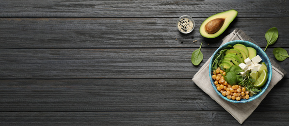 Image of Delicious avocado salad and space for text on black wooden table, flat lay. Banner design