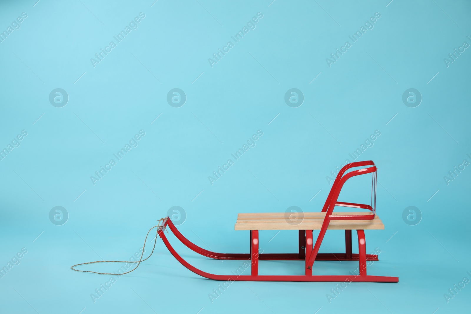 Photo of Stylish sleigh on light blue background, space for text