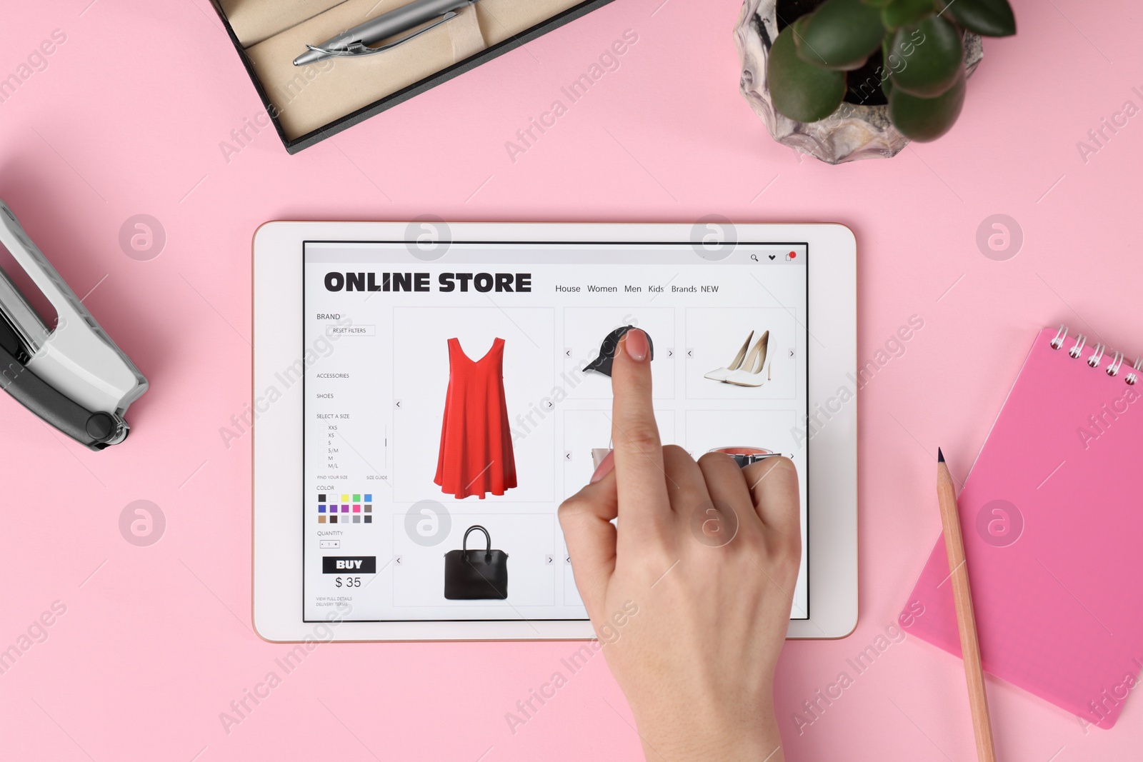 Photo of Woman with tablet shopping online on pink background, top view