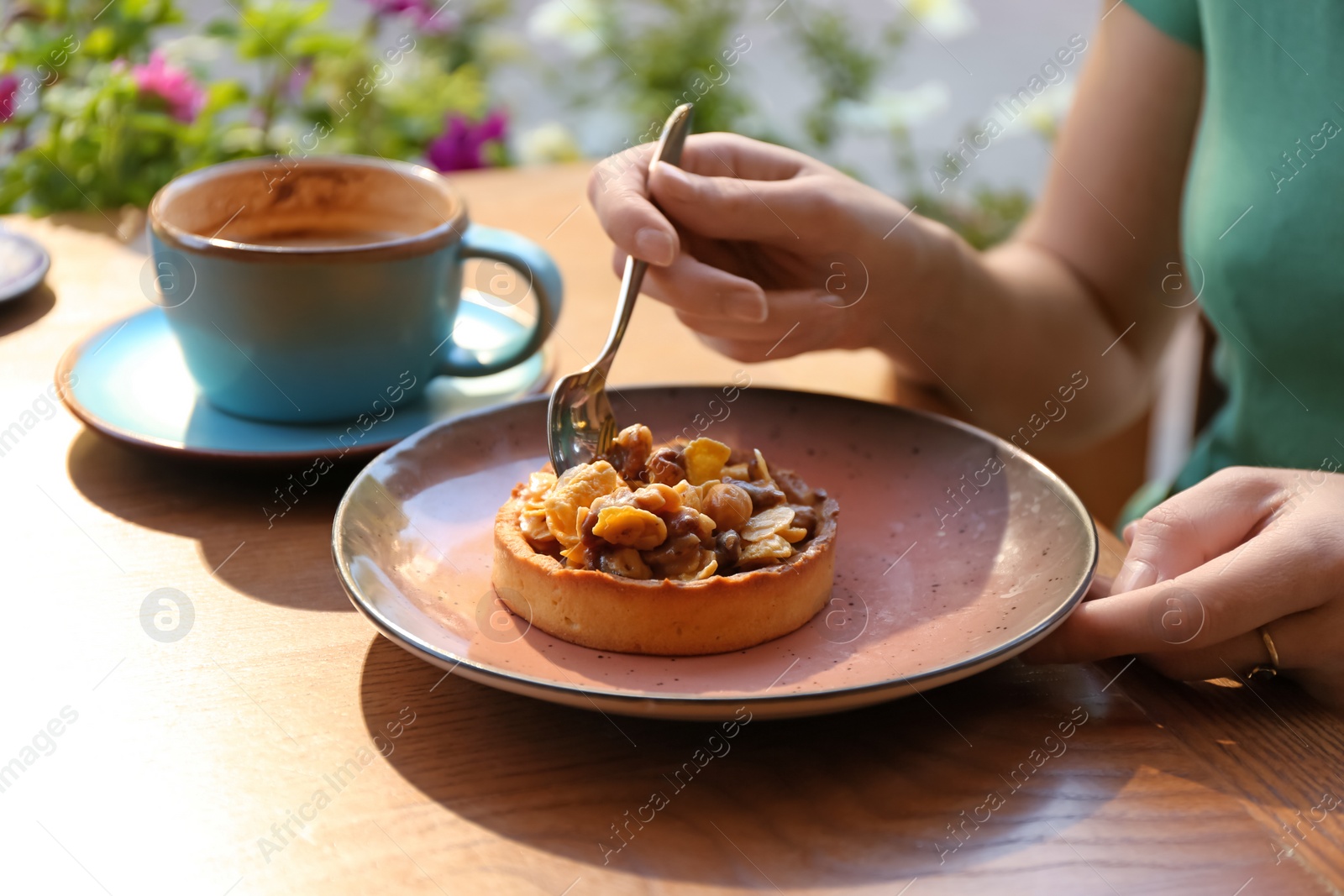 Photo of Woman eating delicious cake at table, closeup