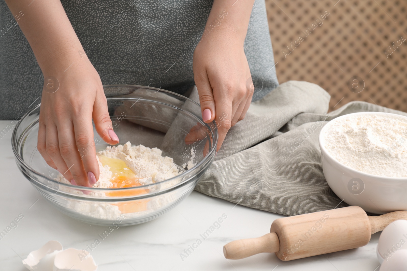 Photo of Preparing tasty baklava. Woman making dough at white marble table, closeup