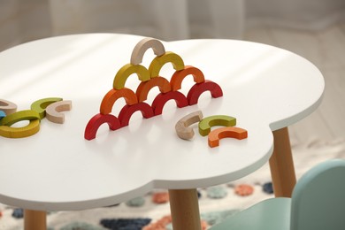 Colorful wooden pieces of play set on white table indoors. Educational toy for motor skills development
