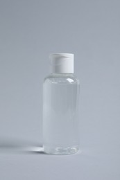 Bottle of cosmetic product on light grey background