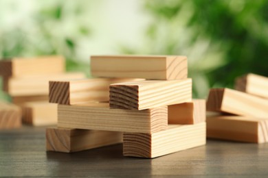 Photo of Wooden blocks on table outdoors. Jenga game