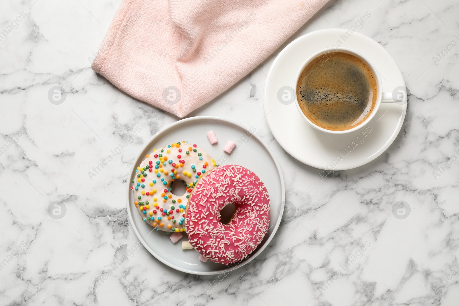 Photo of Yummy donuts with sprinkles and coffee on white marble table, flat lay