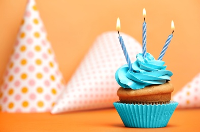 Photo of Birthday cupcake with candles on color background