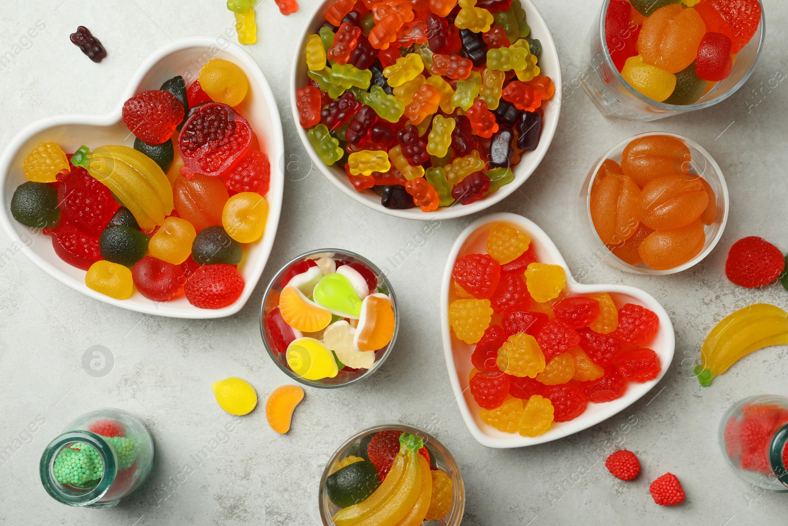 Photo of Delicious gummy candies on light grey table, flat lay