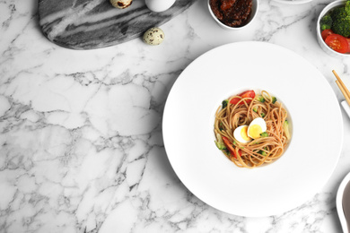 Tasty buckwheat noodles served on white marble table, flat lay. Space for text