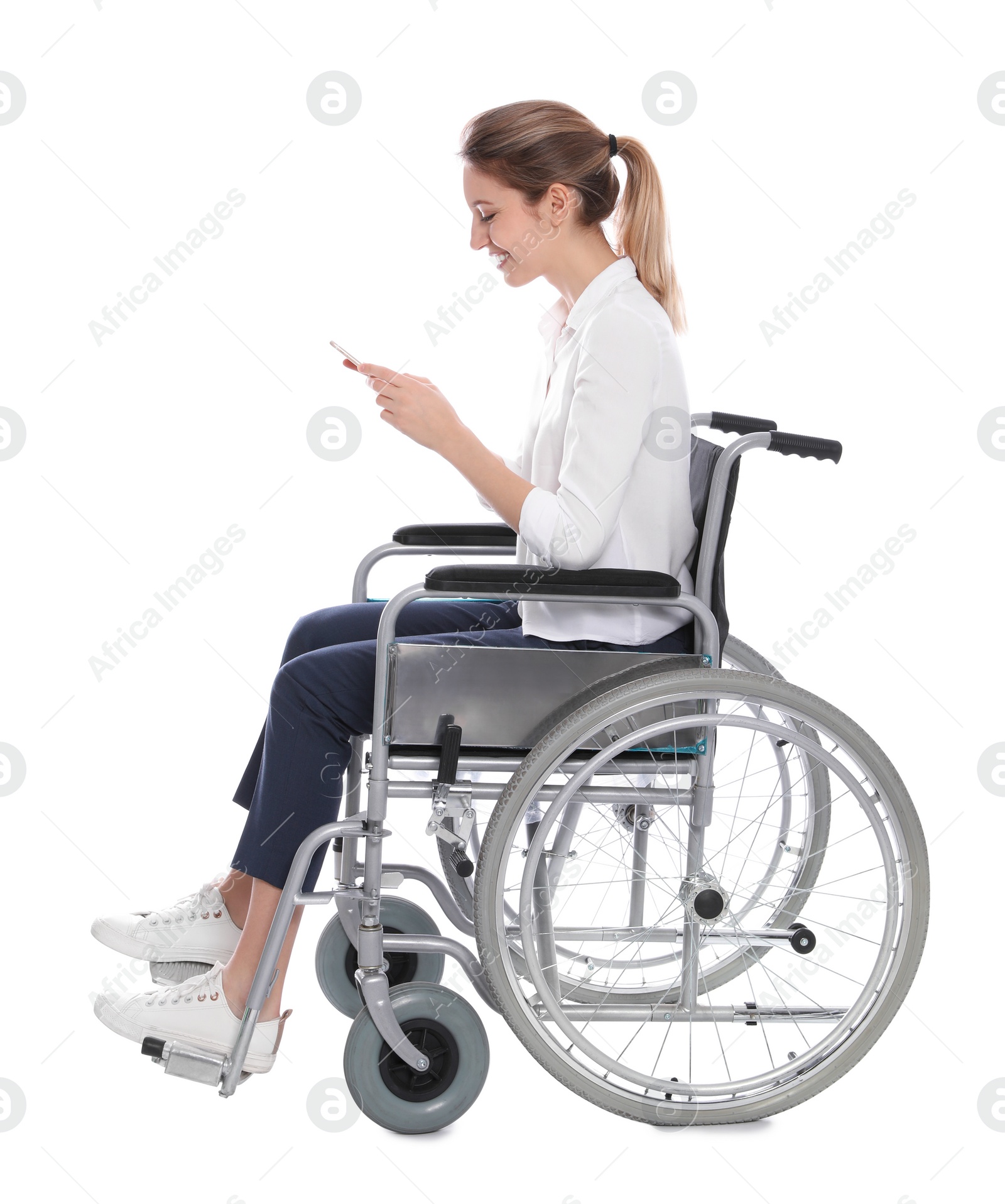Photo of Young woman in wheelchair using mobile phone isolated on white