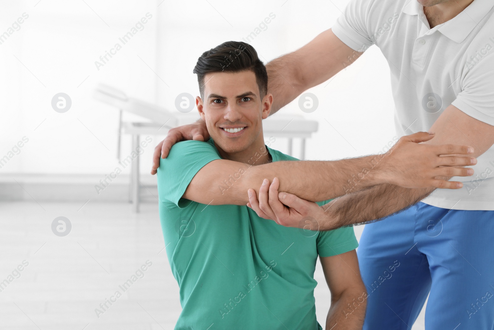 Photo of Professional physiotherapist working with male patient in rehabilitation center