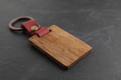 Photo of Wooden keychain with Ukrainian coat of arms on grey background, closeup