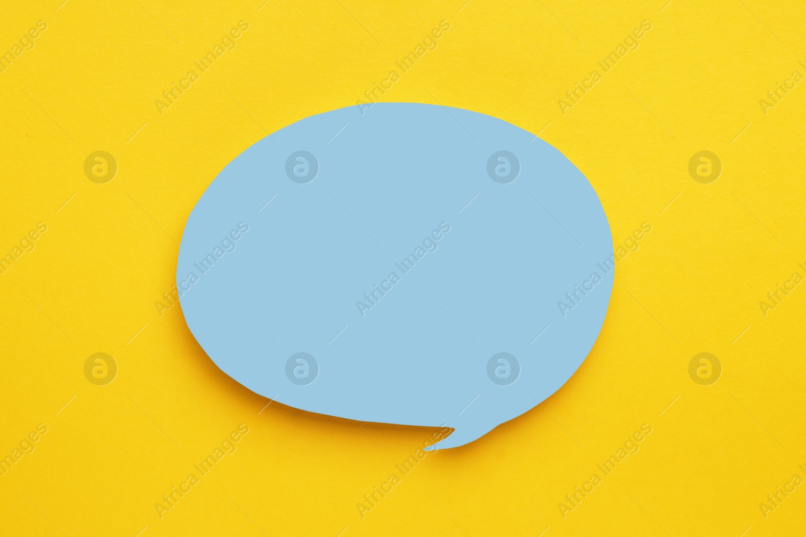 Photo of Paper speech bubble on yellow background, top view. Space for text