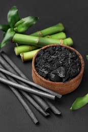 Photo of Fresh bamboo and charcoal on black background