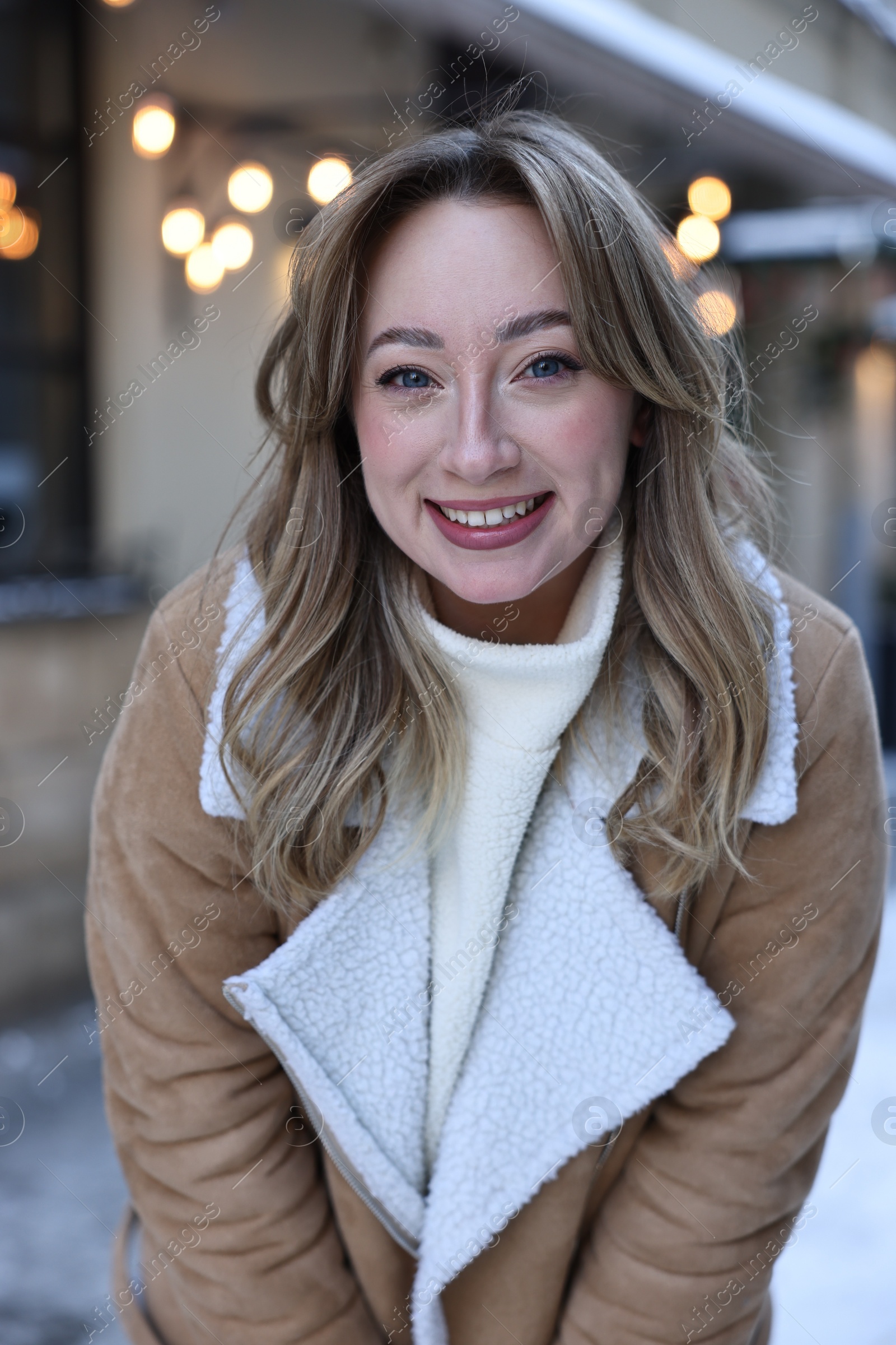 Photo of Portrait of smiling woman on city street in winter