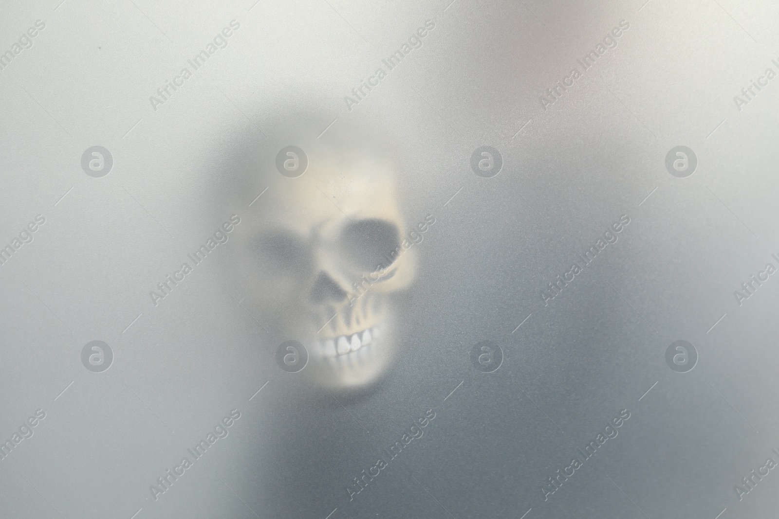 Photo of Silhouette of creepy ghost with skull behind cloth, space for text