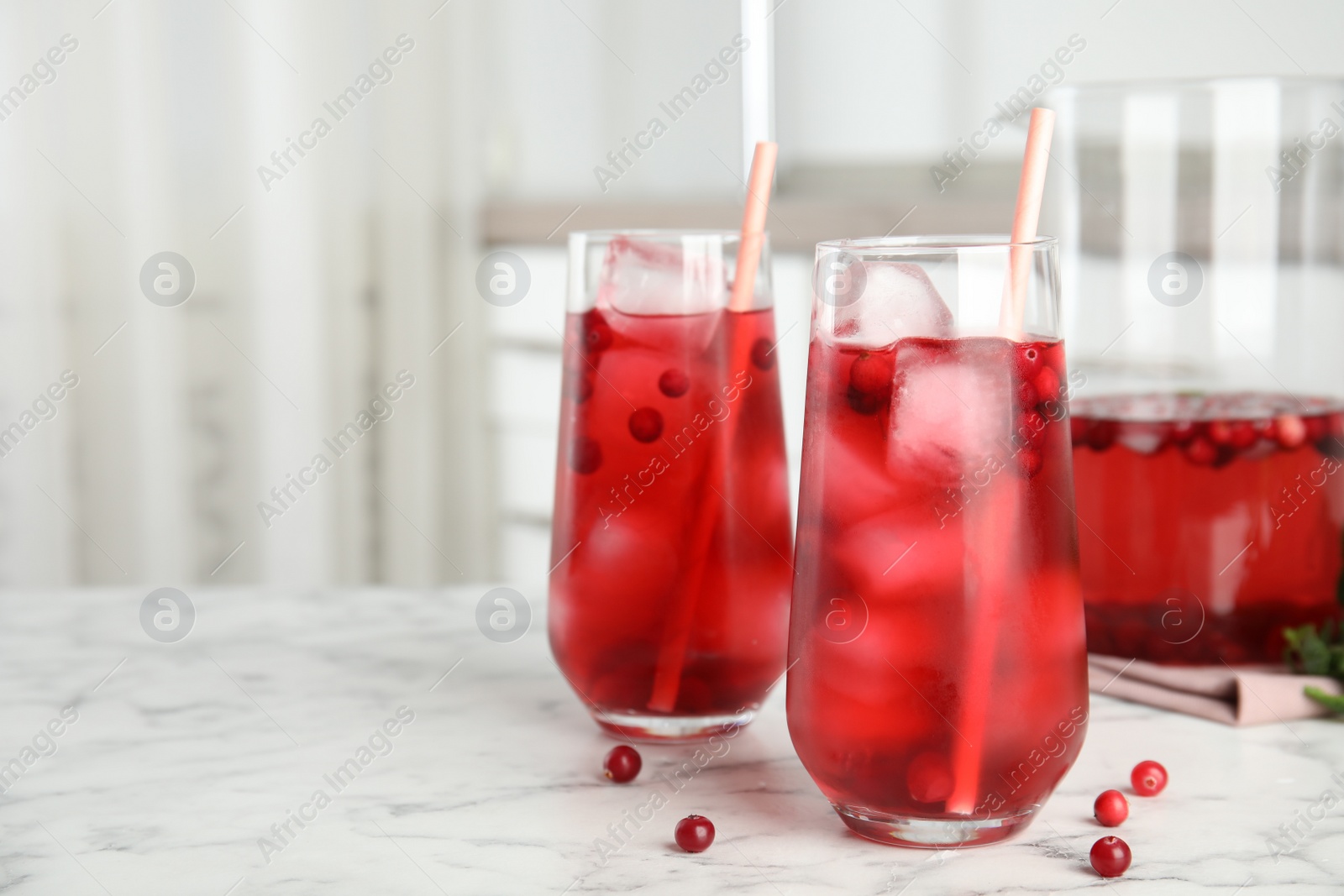 Photo of Tasty refreshing cranberry cocktail on white marble table indoors. Space for text