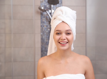 Photo of Portrait of beautiful woman with towel on head in bathroom