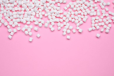 Delicious sweet marshmallows on pink background, flat lay. Space for text