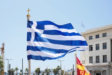 Athens, Greece - May 25, 2022: Beautiful view of Greece flag against blue sky on city street