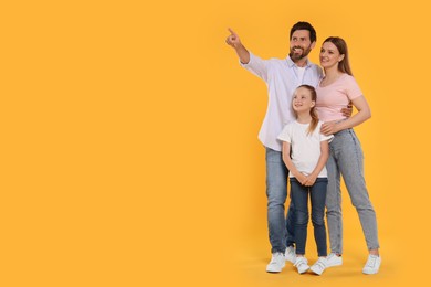 Photo of Happy family on orange background, space for text