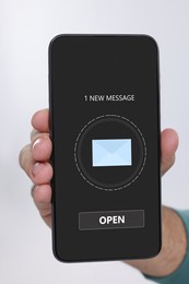Image of Man showing mobile phone with new message notification on screen against white background, closeup