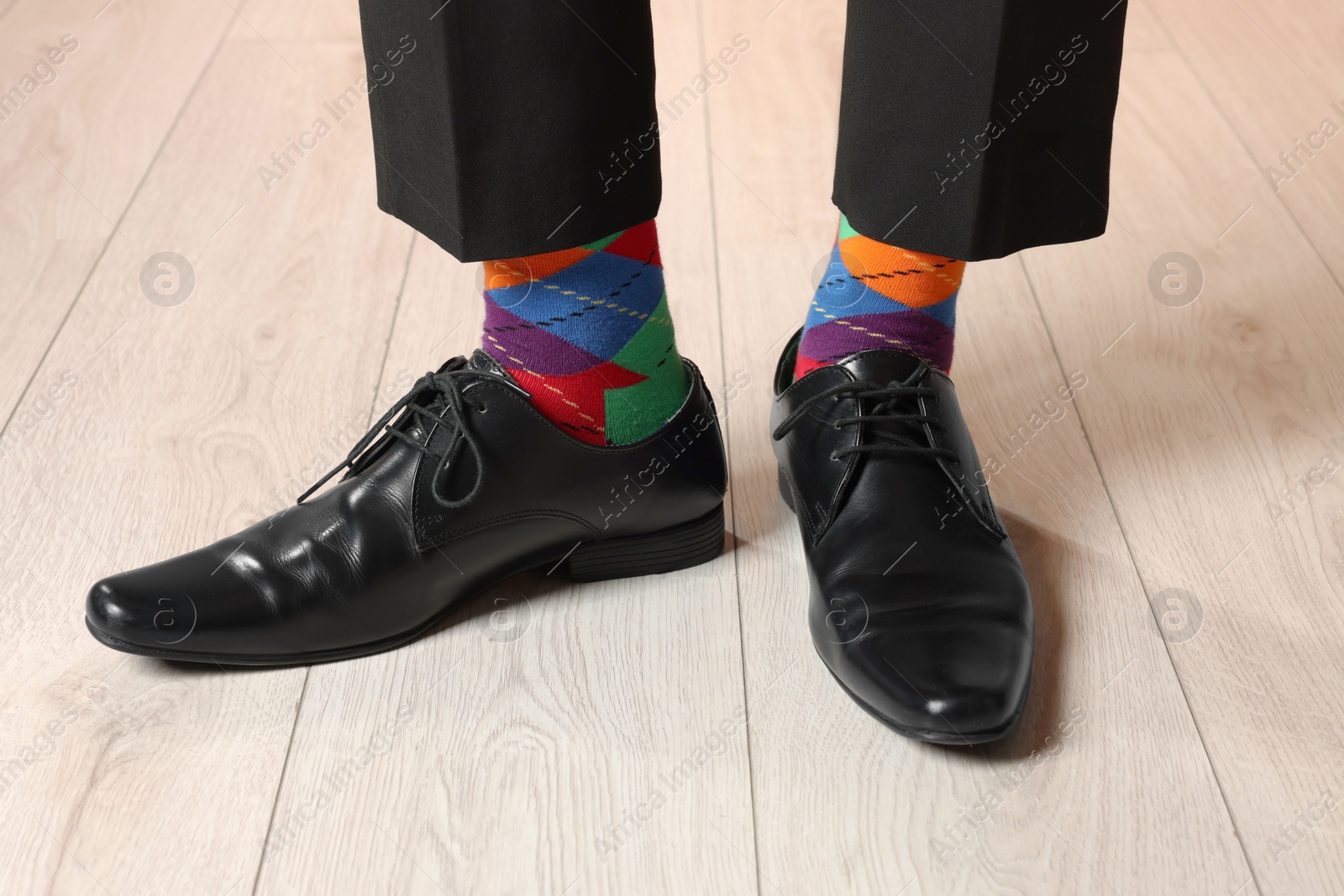 Photo of Man wearing stylish shoes and colorful socks indoors, closeup