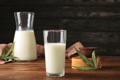 Photo of Glassware with hemp milk on wooden table