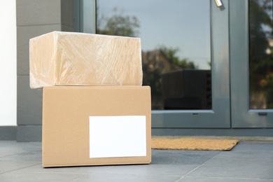 Photo of Cardboard boxes near door. Parcel delivery service