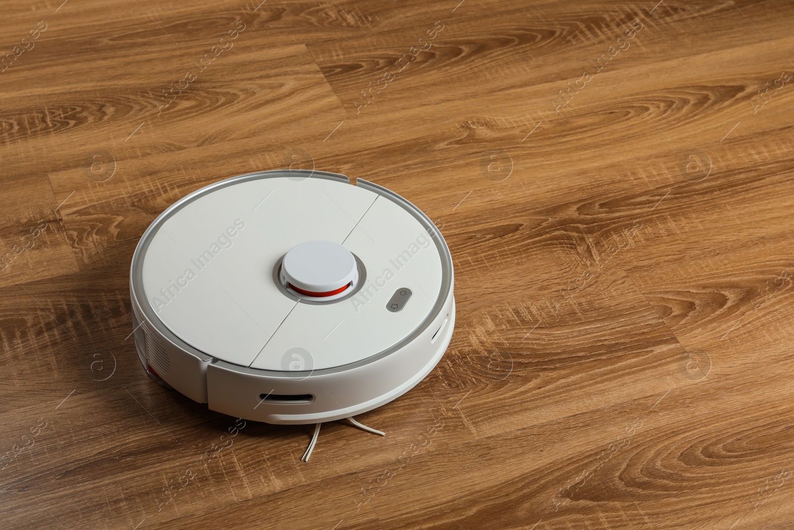 Photo of Robotic vacuum cleaner on wooden floor, space for text