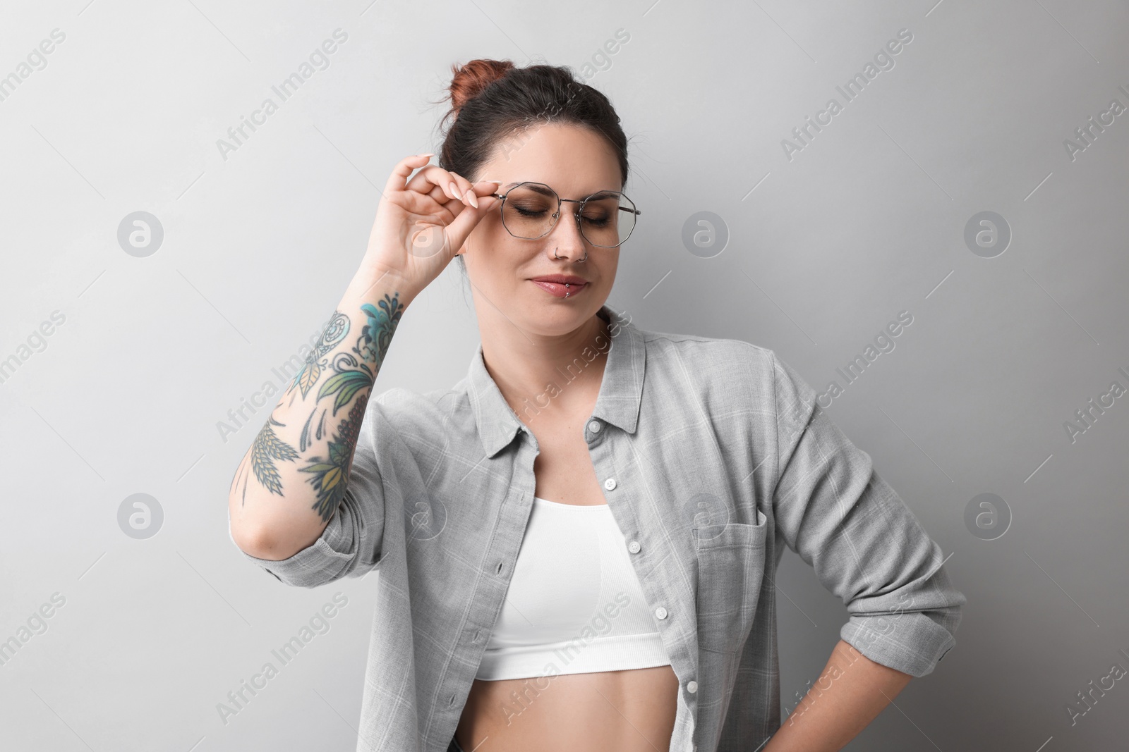 Photo of Portrait of beautiful tattooed woman on gray background