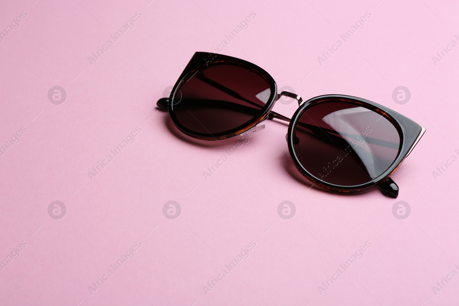 Photo of Stylish sunglasses on pink background, space for text. Fashionable accessory