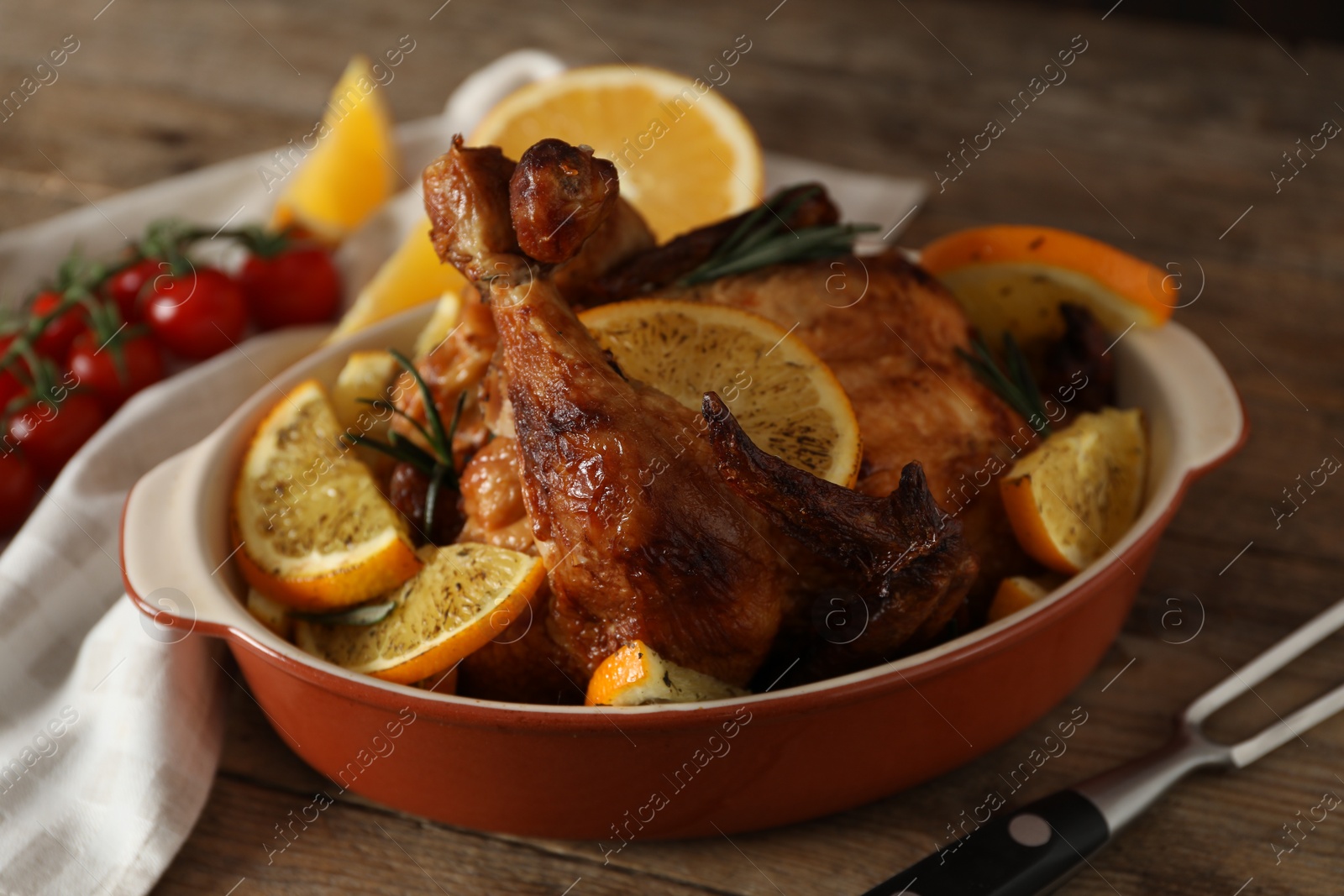 Photo of Baked chicken with orange slices on wooden table
