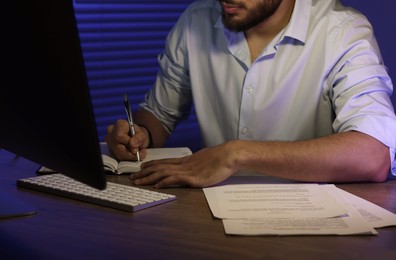 Photo of Man working late at desk in office, closeup
