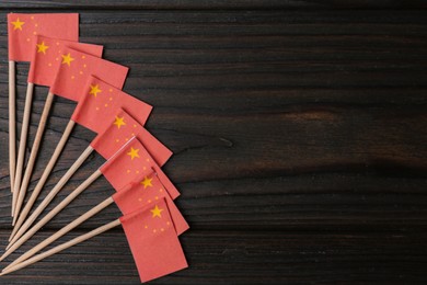 Photo of Small paper flags of China on wooden table, flat lay. Space for text
