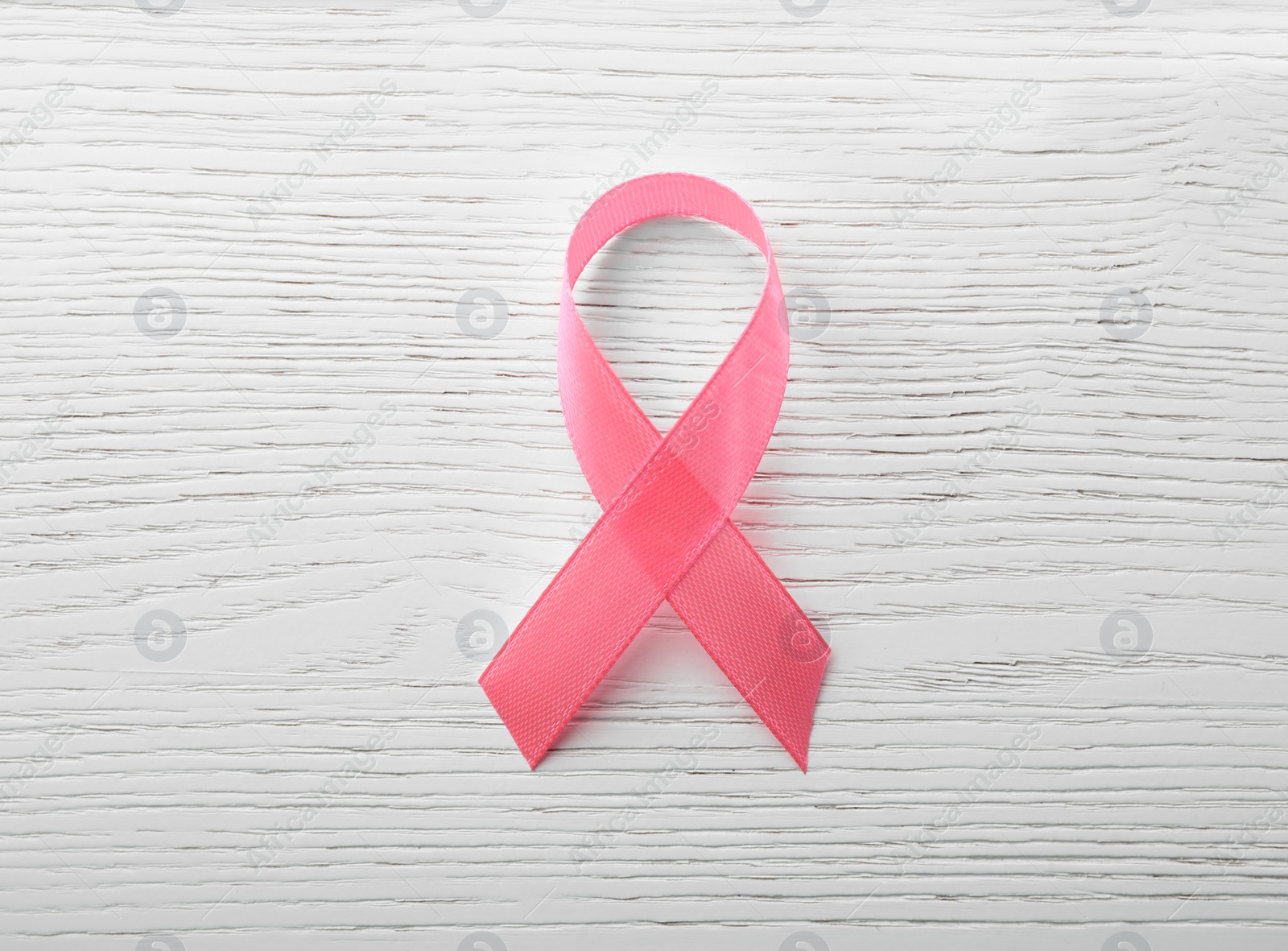 Photo of Pink ribbon on wooden background, top view. Breast cancer awareness concept