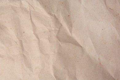 Sheet of crumpled light brown paper as background, top view