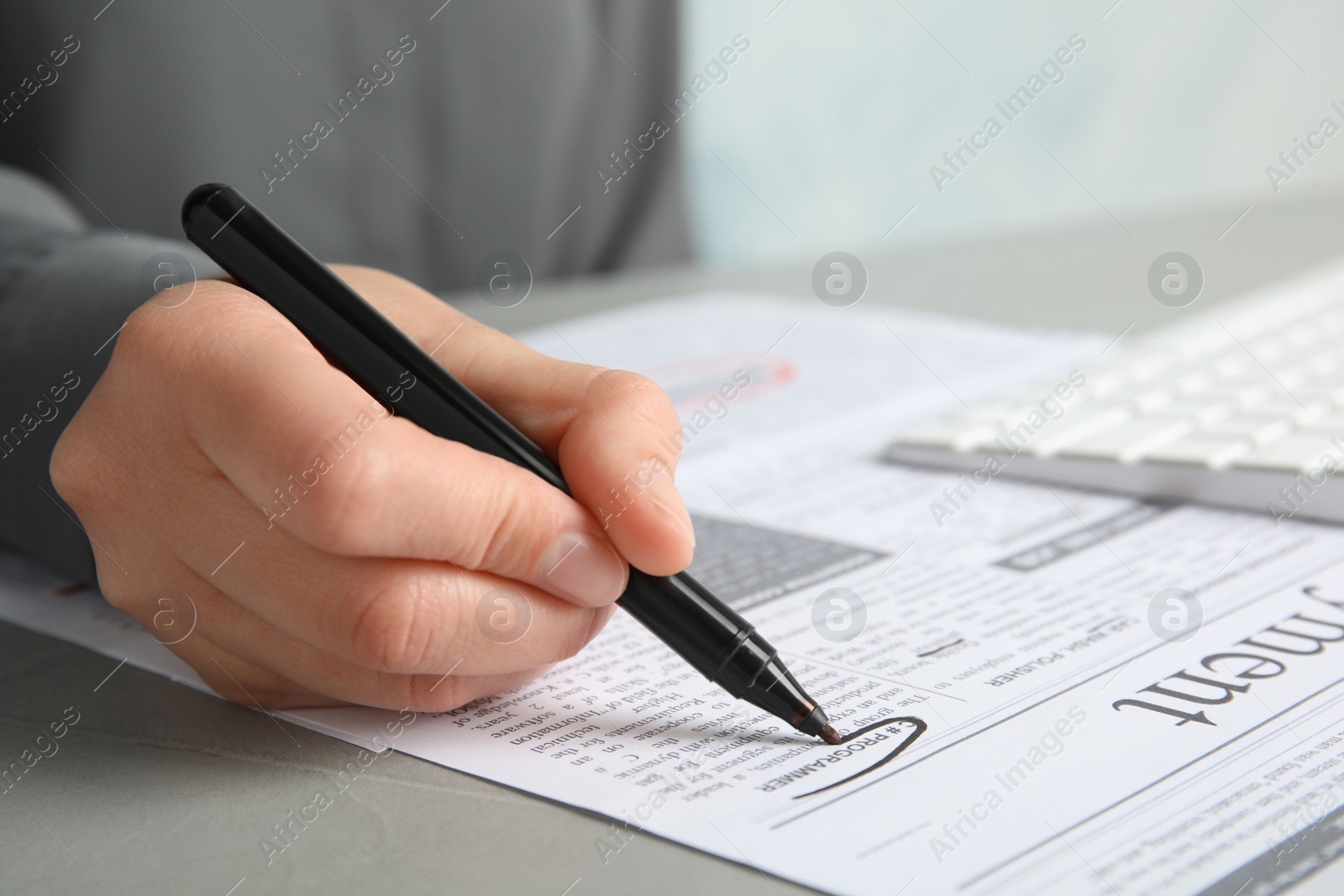 Photo of Woman marking advertisement in newspaper, closeup. Job search concept