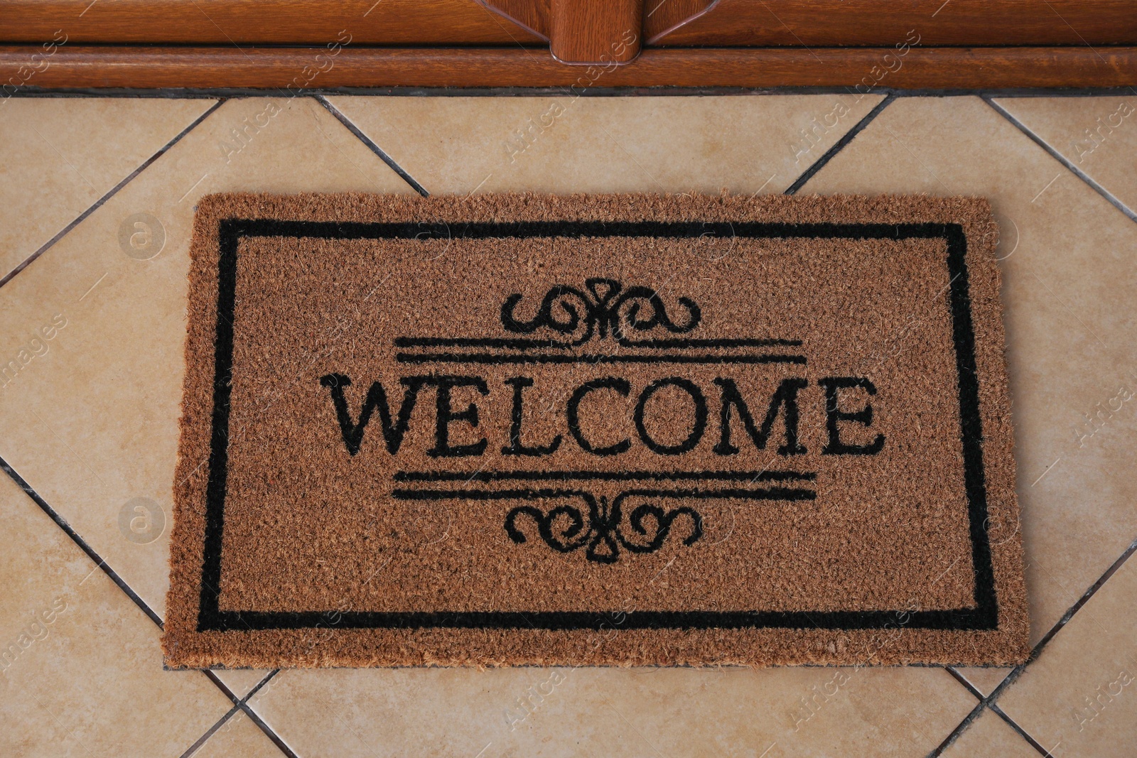 Photo of Door mat with word Welcome on floor, above view