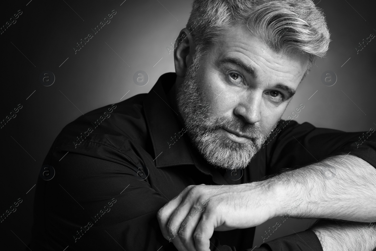 Photo of Portrait of handsome man on dark background. Black and white effect