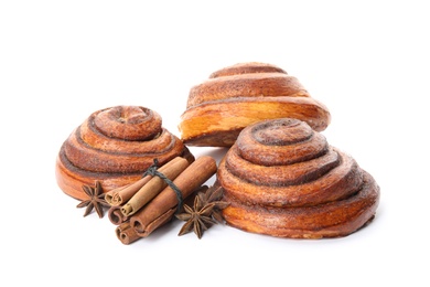 Freshly baked cinnamon rolls with ingredients on white background