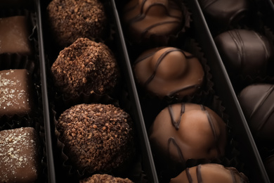 Photo of Many different chocolate candies in box, closeup