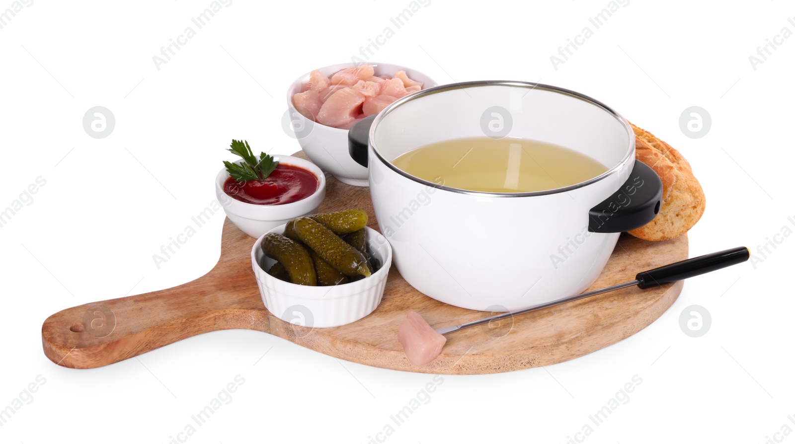 Photo of Oil in fondue pot, fork, pieces of raw meat, pickles and sauce isolated on white