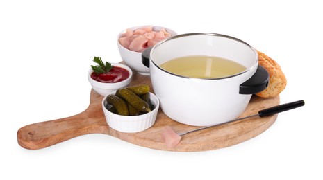 Photo of Oil in fondue pot, fork, pieces of raw meat, pickles and sauce isolated on white