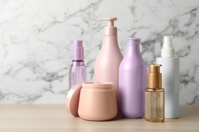 Photo of Different hair care products on wooden table