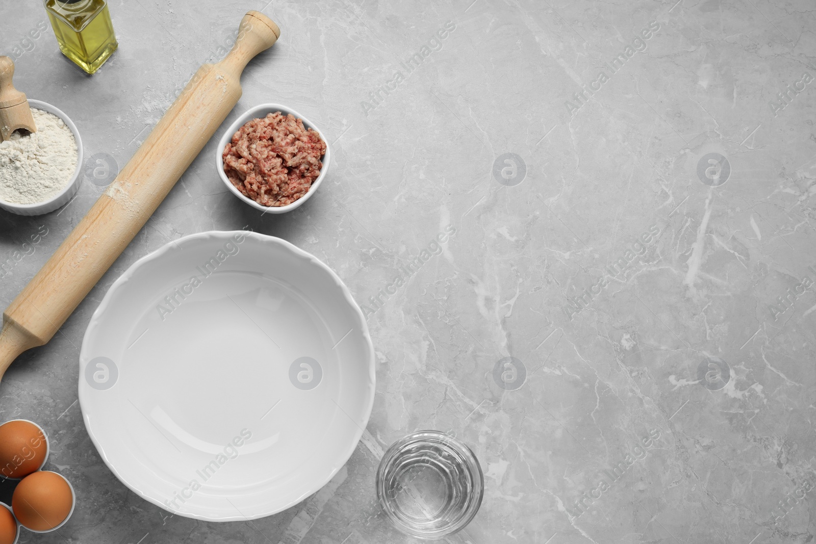 Photo of Bowl and different products on grey table, flat lay. Space for text