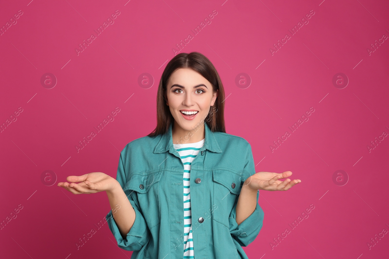 Photo of Portrait of happy young woman on pink background