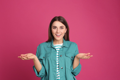 Portrait of happy young woman on pink background