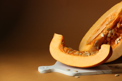 Photo of Cut fresh ripe pumpkin on orange background. Space for text