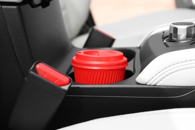 Takeaway paper coffee cup in holder inside car