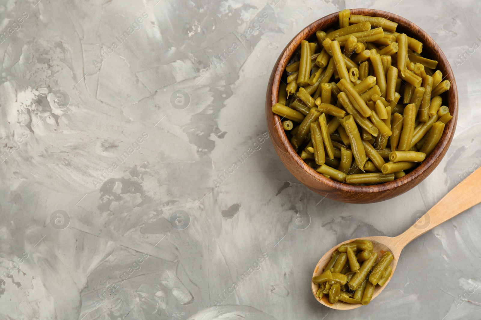 Photo of Canned green beans on grey table, flat lay. Space for text